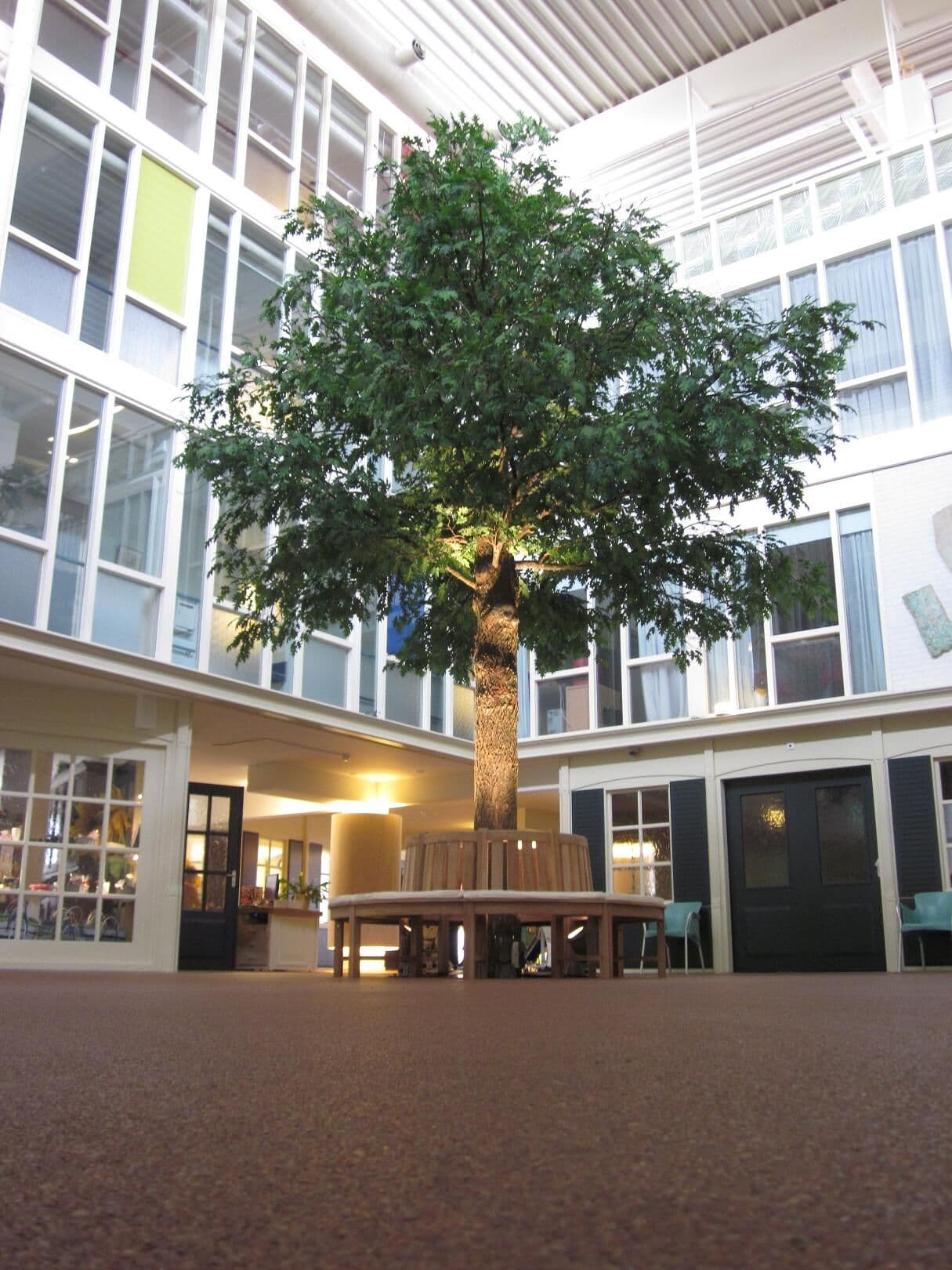 Kunstboom met rondbank in een atrium